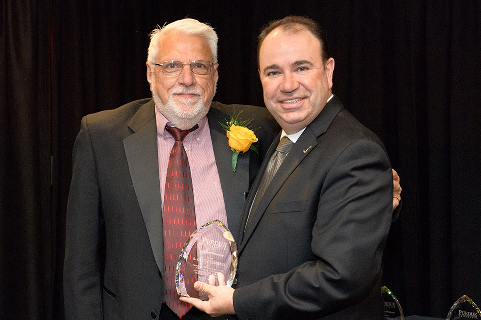 Dr. Hollenbeck receives his award from the Purdue University College of Pharmacy.