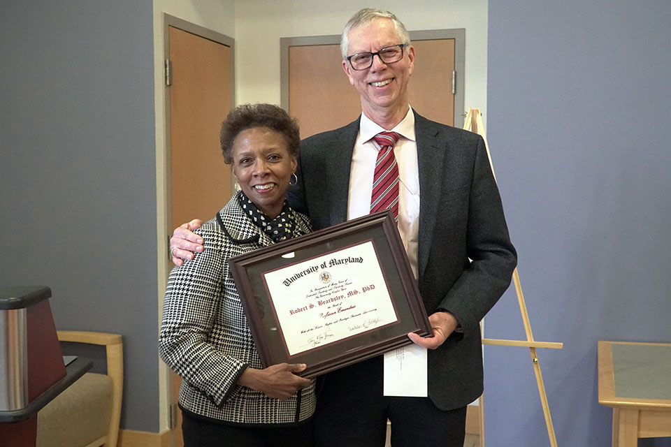 Dr. Beardsley poses for photo with Dr. Eddington holding certificate naming him professor emeritus.