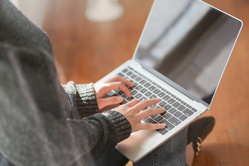 Woman's hands on laptop keyboard.