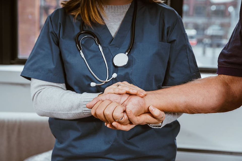 Doctor holds patient's hand.