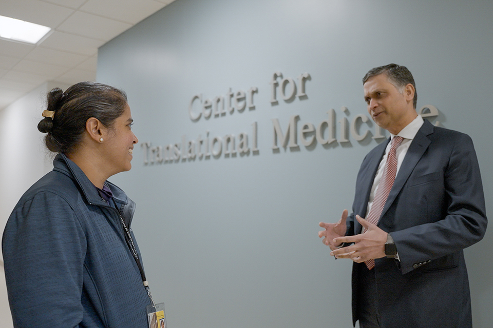 Joga Gobburu and Mathangi Gopalakrishnan talk in front of the Center for Translational Medicine sign.